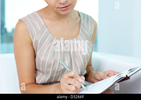Attractive young woman taking notes in order not to forget something Stock Photo