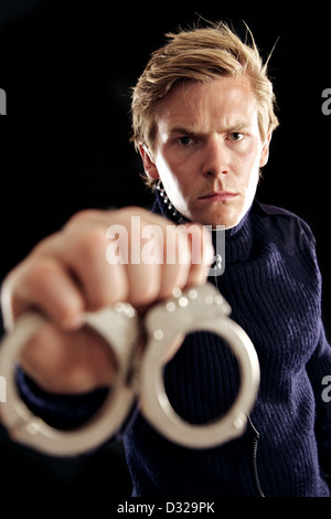 Police officer holding handcuffs Stock Photo - Alamy