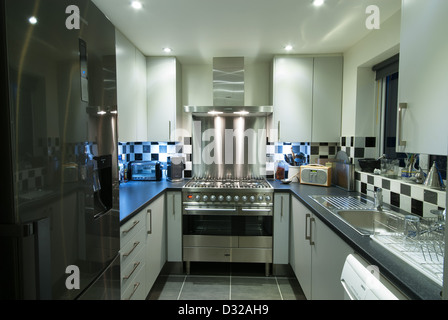 A small, modern domestic kitchen with a stainless steel range cooker. UK, 2013. Stock Photo