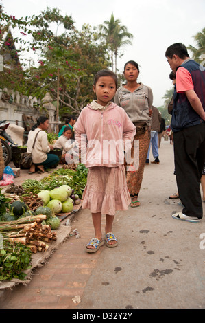 Young girl walks through the morning food market Luang Prabang Laos Stock Photo