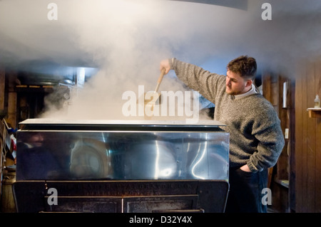 Checking sap as it boils down in the evaporator while making maple syrup, Adirondacks, New York State. Stock Photo