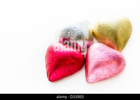 Heart shape chocolate candies wrapped in colorful foil for Valentine's Day. Stock Photo