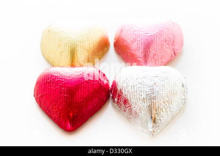 Heart shape chocolate candies wrapped in colorful foil for Valentine's Day. Stock Photo