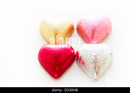 Heart shape chocolate candies wrapped in colorful foil for Valentine's Day. Stock Photo