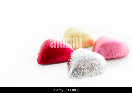 Heart shape chocolate candies wrapped in colorful foil for Valentine's Day. Stock Photo