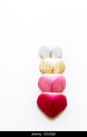 Heart shape chocolate candies wrapped in colorful foil for Valentine's Day. Stock Photo