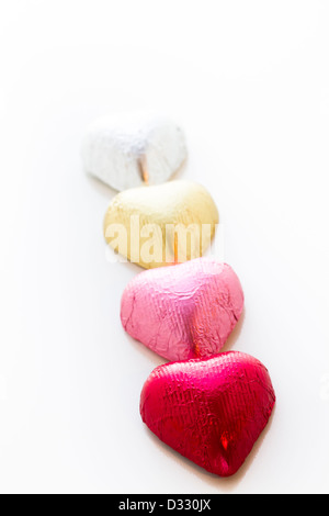 Heart shape chocolate candies wrapped in colorful foil for Valentine's Day. Stock Photo