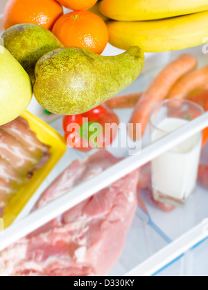 Open fridge full of fruits, vegetables and meat with marked calories Stock Photo