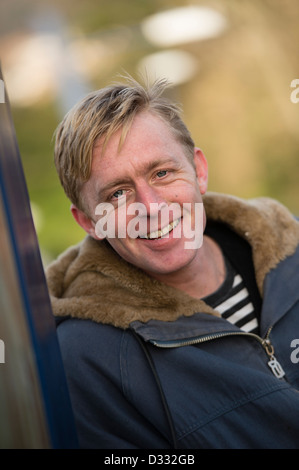 A slim blonde man male, late 30's / early 40's, single solo alone, smiling happy confident, UK Stock Photo