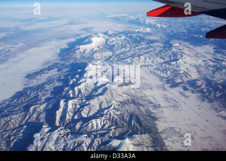 Nephi, Utah, USA. 7th February 2013. An airliner cruising at over 30,000 feet affords a spectacular view of the Wasatch Range of the Rocky Mountains dressed in wintry white. Seen in this view to the north are the towns of Nephi, left center, and and Fountain Green in the valley at lower right. Utah Lake and the city of Provo are in the distance at top with Mount Nebo being the prominent, white ridge and peak just left of  top center. Stock Photo