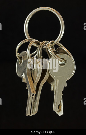 Set of steel small keys on keyring against black background Stock Photo