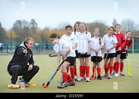 A games teacher instructs girls during hockey practice at Pates Grammar School in Cheltenham, Gloucestershire UK Stock Photo