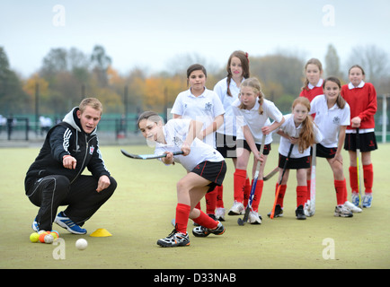 A games teacher instructs girls during hockey practice at Pates Grammar School in Cheltenham, Gloucestershire UK Stock Photo