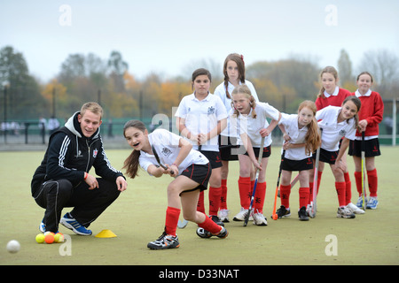 A games teacher instructs girls during hockey practice at Pates Grammar School in Cheltenham, Gloucestershire UK Stock Photo