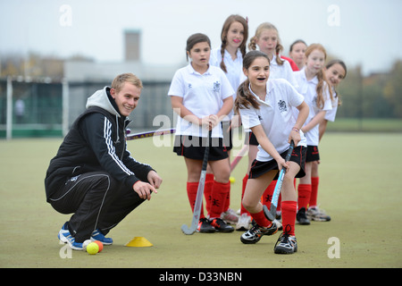 A games teacher instructs girls during hockey practice at Pates Grammar School in Cheltenham, Gloucestershire UK Stock Photo