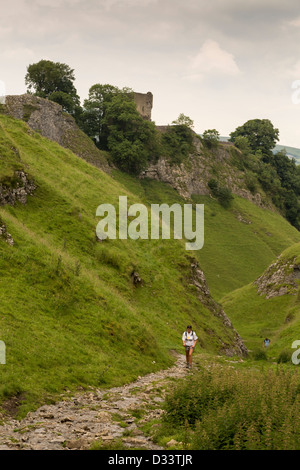 Single person walking in Cave Dale with Peveril castle in the background Derbyshire Peak District England Stock Photo