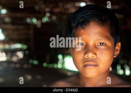 A Yagua young boy inside a maloca (traditional house with thatched roof), surroundings of Iquitos, Amazonian Peru Stock Photo