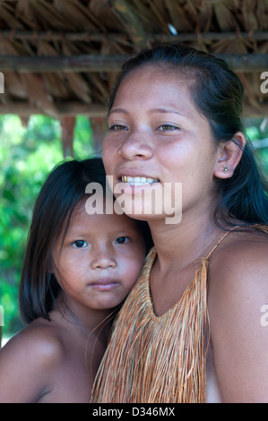 A Yagua young girl and a young woman with thatch vest, surroundings of Iquitos, Amazonian Peru Stock Photo