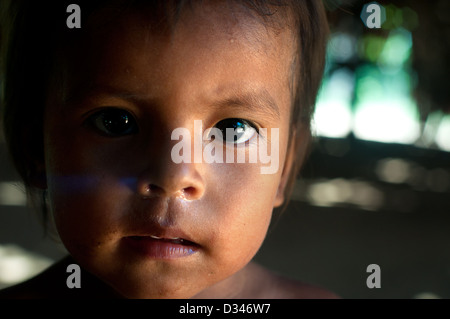 A Yagua young boy inside inside a maloca (traditional house with thatched roof), surroundings of Iquitos Stock Photo