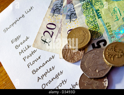 Close up of shopping list with UK coins and banknotes on top Stock Photo