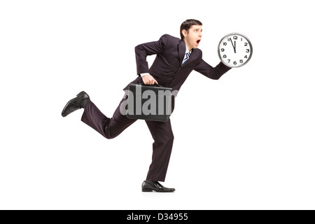 Full length portrait of a busy businessman running with wall clock and briefcase isolated on white background Stock Photo
