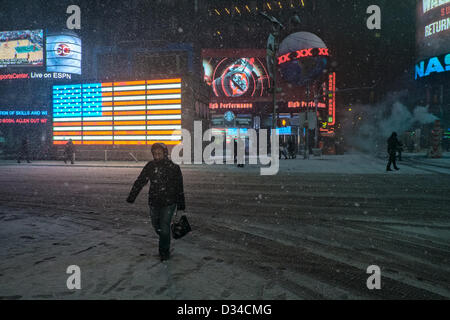 New York, USA. 8th February 2013. A woman crosses 7th Avenue near Times Square as snow falls from a winter storm that is forecast to bring up to two feet of snow to parts of the northeast United States. Credit:  Joseph Reid / Alamy Live News Stock Photo