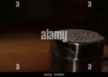 Close-up of a flour shaker in a country kitchen with wooden rolling pin in background Stock Photo