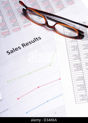 Business Charts and graphs showing sales results with a pair of glasses Stock Photo