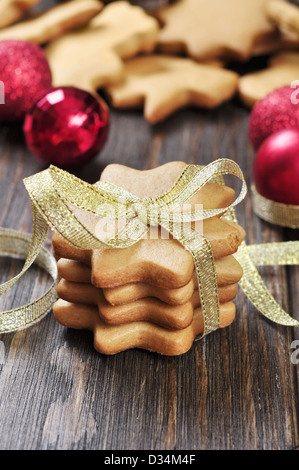 Christmas cookies in shape of stars with golden ribbon on wooden background Stock Photo