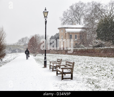 Man walks along snow covered tow path of the Thames rIver near Asgill House, Richmond upon Thames,Greater London, Surrey Stock Photo