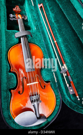 modern small violin with bow in green velvet case close up Stock Photo