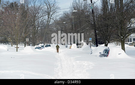Newhaven, Connecticut, USA. 9th February 2013. Man cross country skis down street with cars buried after snowstorm Nemo drops 34 inches of snow in New Haven, CT. Credit:  Michael Doolittle / Alamy Live News Stock Photo