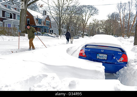 Newhaven, Connecticut, USA. 9th February 2013. Man cross country skis down street with cars buried after snowstorm Nemo drops 34 inches of snow in New Haven, CT. Credit:  Michael Doolittle / Alamy Live News Stock Photo