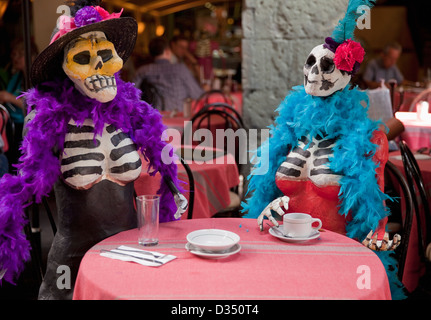 Dressed-up papier mache skeletons sitting at cafe table on Zocalo during Day of the Dead, Oaxaca, Mexico. Stock Photo