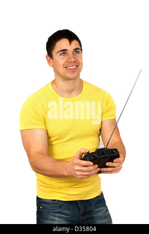 Young athletic man holding a radio remote control (controlling handset) for helicopter or plane.Isolated on white background Stock Photo