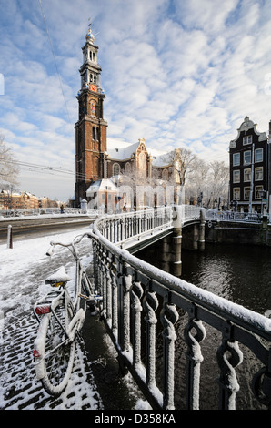Snow covered bridge over the Prinsengracht canal, with Westerkerk in the background, Amsterdam, the Netherlands Stock Photo
