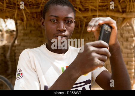 Barsalogho, Burkina Faso, May 2012: A boy takes a photograph on his mobile phone. Stock Photo
