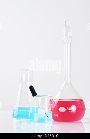 Different laboratory glassware with light blue liquid isolated on white ...