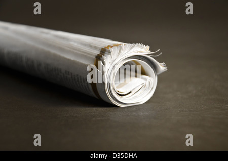 Roll of newspapers isolated on dark background Stock Photo