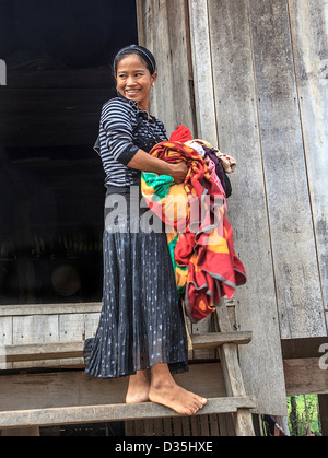 Young woman carries laundry, one of Cham people living in a village along the Mekong River south of Kratie, Cambodia. Stock Photo