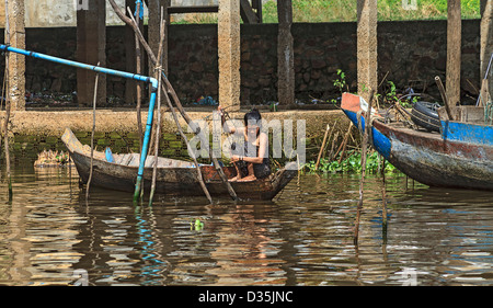 Local woman catches fish in Kompong Plu, ka group of three stilt house villages near Siem Reap, Cambodia Stock Photo