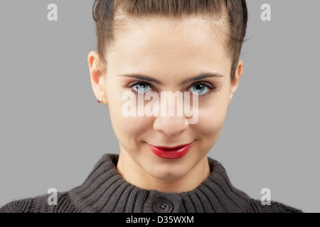 Portrait of a beautiful young woman with blue eyes isolated on grey Stock Photo