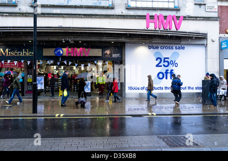 Shoppers with umbrellas to protect them from the snow rush past the faltering  HMV store on Oxford Street on 14/01/2013. Picture by Julie Edwards Stock Photo