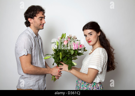 Man handing bouquet of flowers to woman Stock Photo