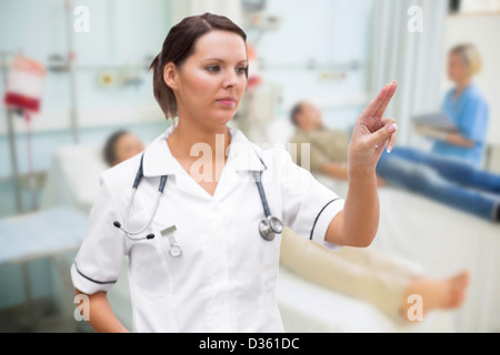Nurse pressing on invisible screen Stock Photo