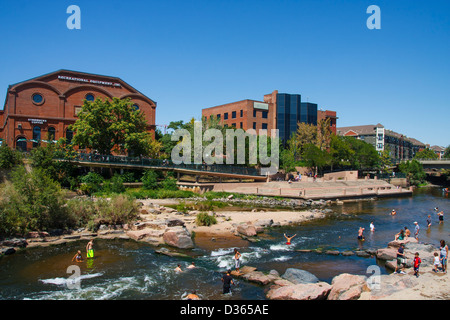 Many people cooling off in the Platte River in Denver near Conluence Park Stock Photo