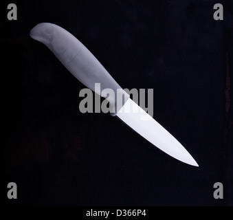 A knife with white ceramic blade over black background Stock Photo