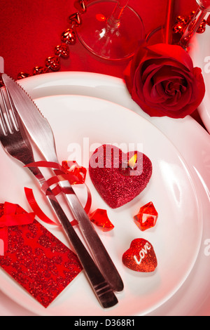 Beautiful table setting with red rose, paper heart and gift box on ...