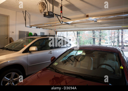 Automobiles in Two Car Suburban Garage with Wasp's Nest Overhead, USA Stock Photo