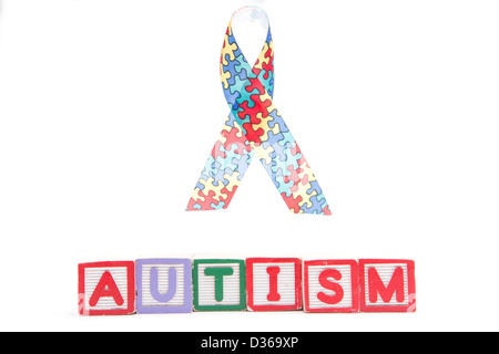 Autism awareness ribbon above letter blocks spelling autism Stock Photo